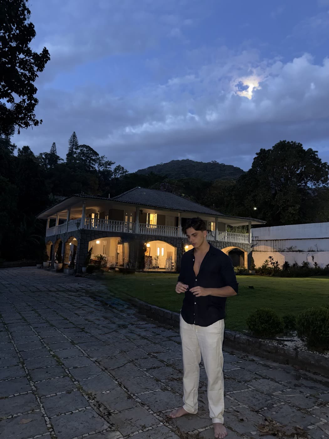 Enrico na frente de uma casa ao entardecer